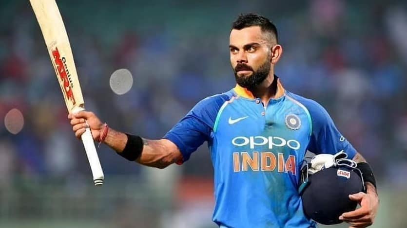 Virat Kohli holding up a bat. Can his men defeat the Aussies? Our India tour of Australia betting tips for the first T20I says they can!